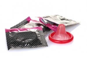 Red condom with  packings isolated on white